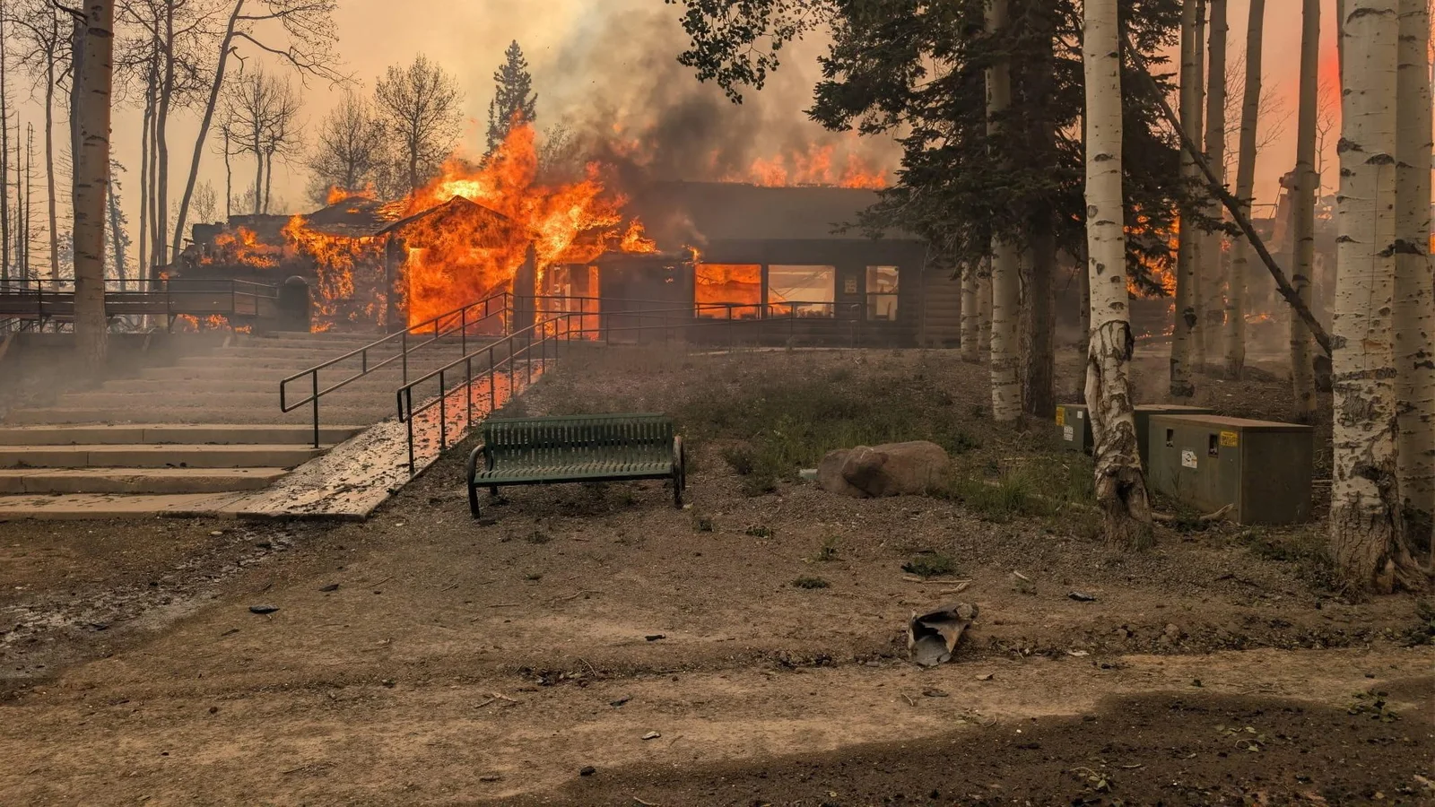 A building burns among aspen trees during the Cottonwood Fire.